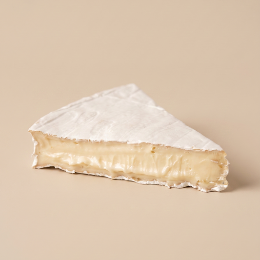 Queso Brie artesanal sobre fondo beige.